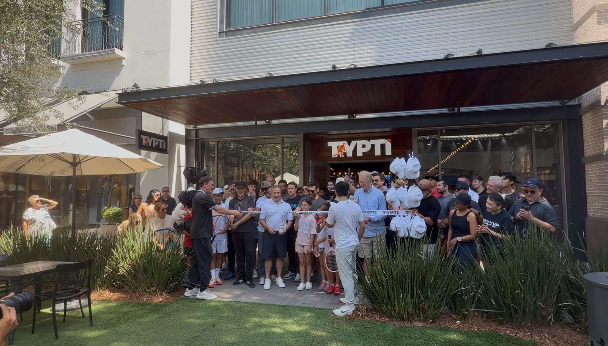 Ribbon cutting with a crowd outside the TYPTI store